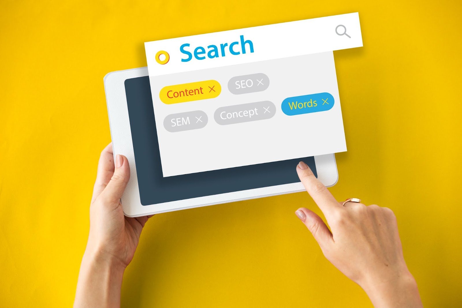 Tablet em um fundo amarelo e na tela aparecem ferramentas de pesquisa e palavras-chave do marketing digital